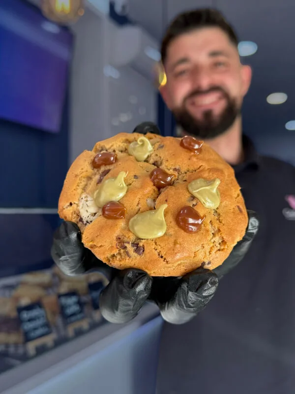 Primer plano de cookie con dulce de leche y pistacho